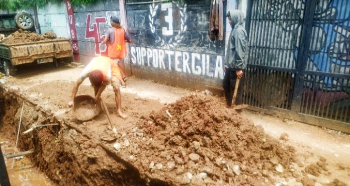 Tampak pekerja tenaga berat pembangunan drainase tanpa APD, mengkhawatirkan keselamatan diri. (dok. Pikiranrakyat.org/qih)