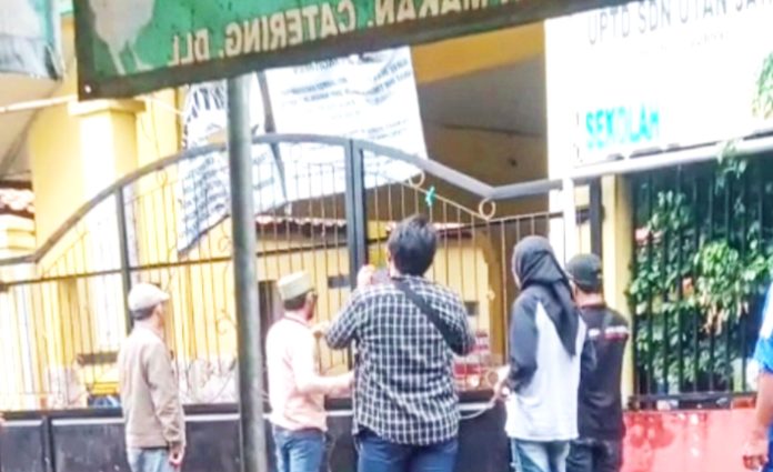 Terlihat ahli waris sedang las gerbang SDN Utan Jaya, bentuk protes kepada pihak Pemkot Depok.